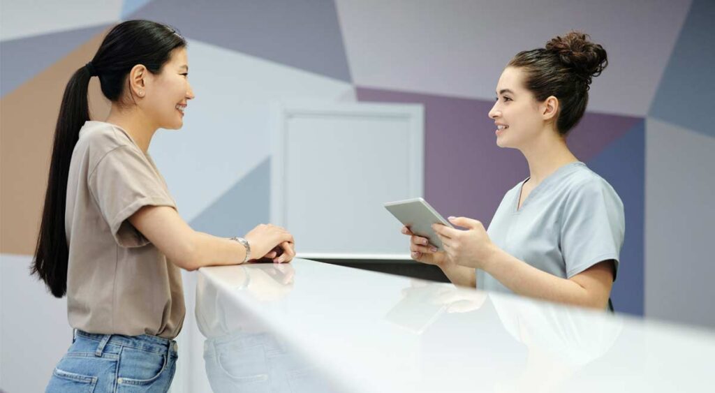 How eSignature Can Improve Your Medical Facility - receptionist using tablet with patient